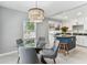 Dining room with modern light fixture, glass table, and kitchen view at 1046 Yale N St, St Petersburg, FL 33713