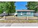 View of a well-maintained green house with a neat yard and a charming wooden fence at 1046 Yale N St, St Petersburg, FL 33713