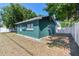 View of house with green exterior, mature trees, and a newly installed white fence at 1046 Yale N St, St Petersburg, FL 33713