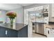 Bright kitchen featuring an island with seating, stainless steel dishwasher, and open shelving at 1046 Yale N St, St Petersburg, FL 33713