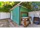 Exterior view of a backyard shed featuring a functional sink, potting bench, and brick-lined pathway at 1046 Yale N St, St Petersburg, FL 33713