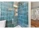 Shower featuring blue accent tiles, built in shelving, brushed gold fixtures and glass door at 1046 Yale N St, St Petersburg, FL 33713