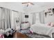 Bright bedroom features hardwood floors, ceiling fan, modern dresser, and decorative mirror at 107 W Amelia Ave, Tampa, FL 33602