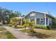 Charming home with a cozy front porch, red door, mature landscaping, and blue siding under a clear blue sky at 107 W Amelia Ave, Tampa, FL 33602