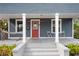 Inviting front porch with a hammock, chairs, and a vibrant red door at 107 W Amelia Ave, Tampa, FL 33602