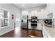 Bright eat-in kitchen boasts stainless appliances, white cabinets, and dark wood floors at 107 W Amelia Ave, Tampa, FL 33602