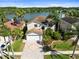 Stunning aerial view of a lakeside home with lush landscaping, paved driveway, and well-manicured lawns at 11503 Whispering Hollow Dr, Tampa, FL 33635