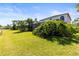 Large backyard with a screened-in pool, green grass, mature landscaping, and view of the lake at 11503 Whispering Hollow Dr, Tampa, FL 33635