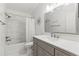 Well-lit bathroom featuring a shower-tub combo with modern tiling and a sleek vanity with a large mirror at 11503 Whispering Hollow Dr, Tampa, FL 33635
