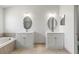 Bright bathroom with double sinks, modern vanities, a soaking tub and updated fixtures at 11503 Whispering Hollow Dr, Tampa, FL 33635