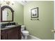 Powder room with decorative mirror, framed art, dark wood cabinets, and tile floor at 11503 Whispering Hollow Dr, Tampa, FL 33635