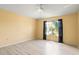 Empty bedroom features laminate flooring, a ceiling fan, and a view of the backyard at 11503 Whispering Hollow Dr, Tampa, FL 33635