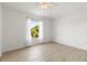 Bright, empty bedroom with light wood flooring, a ceiling fan, and a window with sheer curtains at 11503 Whispering Hollow Dr, Tampa, FL 33635