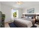 Modern bedroom with sleek furniture, plush bedding, and a large window showcasing exterior greenery at 11503 Whispering Hollow Dr, Tampa, FL 33635