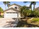 Charming home featuring a two-car garage, lush landscaping, and a brick paver driveway at 11503 Whispering Hollow Dr, Tampa, FL 33635
