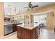Open kitchen with stainless steel appliances, granite countertops, kitchen island and a view of the pool and lake at 11503 Whispering Hollow Dr, Tampa, FL 33635