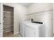 Functional laundry room with shelving, a washer, and a dryer for convenient home chores at 11503 Whispering Hollow Dr, Tampa, FL 33635