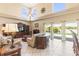 Bright living room with high ceilings, ceiling fan, decorative windows, tile floors, and view of the pool at 11503 Whispering Hollow Dr, Tampa, FL 33635