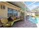 Comfortable covered patio with ample seating, string lights, and a view of the backyard pool at 11503 Whispering Hollow Dr, Tampa, FL 33635