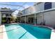 Backyard pool surrounded by a screened enclosure, offering a private retreat with covered patio and palm trees at 11503 Whispering Hollow Dr, Tampa, FL 33635