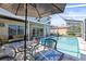 Covered patio area and pool with a screen enclosure, glass table, and view of the backyard at 11503 Whispering Hollow Dr, Tampa, FL 33635