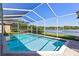 Sparkling in-ground pool inside a screened enclosure with brick pavers and tranquil lake views at 11503 Whispering Hollow Dr, Tampa, FL 33635
