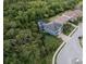 Aerial view of a blue home with a screened in pool area surrounded by trees and greenery at 12026 Medley Ter, Lakewood Ranch, FL 34211