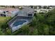 Aerial view of a home with a screened in pool area surrounded by trees and greenery at 12026 Medley Ter, Lakewood Ranch, FL 34211