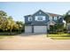 Charming two-story blue home featuring a three-car garage and well-manicured lawn at 12026 Medley Ter, Lakewood Ranch, FL 34211