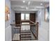 Upstairs hallway with coffered ceiling, wood sliding doors and iron railing at 12026 Medley Ter, Lakewood Ranch, FL 34211