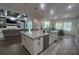 Modern kitchen with stainless appliances, granite counters, and large island open to the living room at 12026 Medley Ter, Lakewood Ranch, FL 34211