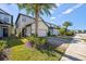 Charming two-story home featuring a two-car garage, beautiful landscaping, and a welcoming front entrance with a palm tree at 1227 Ballard Green Pl, Brandon, FL 33511