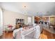 Open concept living room and kitchen with hardwood floors, a large sectional, flat screen TV, and modern lighting fixtures at 1227 Ballard Green Pl, Brandon, FL 33511