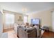 Bright living room with hardwood floors, a large sectional sofa, flat screen TV, and lots of natural light at 1227 Ballard Green Pl, Brandon, FL 33511