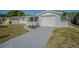 Charming single-story home with a screened-in porch and an attached garage with a driveway at 1264 Chelsea Ln, Holiday, FL 34691