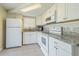 Well-lit kitchen features white appliances, granite countertops, and tile backsplash at 1264 Chelsea Ln, Holiday, FL 34691