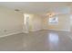 A bright living room with neutral paint, gray floors, ceiling fan, and a window at 1264 Chelsea Ln, Holiday, FL 34691