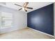 Cozy bedroom with dark blue accent wall, carpet, and ample natural light at 12719 Saulston Pl, Hudson, FL 34669