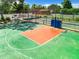 Up high view of a green and red outdoor basketball court with hoop and net in a fenced in area at 12920 Wedgewood Way # A, Hudson, FL 34667