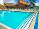 Large community pool with clear blue water, steps entry, and shaded lounging areas at 12920 Wedgewood Way # A, Hudson, FL 34667