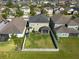 Aerial view of a fenced backyard including a covered patio with green grass, shrubbery, and manicured lawn at 13639 Ashlar Slate Pl, Riverview, FL 33579