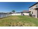 Spacious backyard with a white vinyl fence, green grass, and access to a tranquil lake at 13639 Ashlar Slate Pl, Riverview, FL 33579