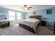 Comfortable bedroom with a large bed, soft carpet, plenty of natural light and cool wall art at 13639 Ashlar Slate Pl, Riverview, FL 33579