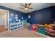 Bright bedroom featuring dark blue walls, ceiling fan, and decorative elements at 13639 Ashlar Slate Pl, Riverview, FL 33579