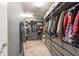 Well-organized walk-in closet with custom shelving, drawers, and ample storage space for clothes and accessories at 13639 Ashlar Slate Pl, Riverview, FL 33579