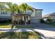 Inviting two-story home with a well-manicured lawn, palm trees, and a two-car garage at 13639 Ashlar Slate Pl, Riverview, FL 33579