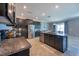 Gourmet kitchen featuring dark cabinets, granite countertops, stainless steel appliances and tile floors at 13639 Ashlar Slate Pl, Riverview, FL 33579