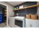 Modern laundry room with new washer and dryer and open shelving for storage at 13639 Ashlar Slate Pl, Riverview, FL 33579