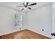 Cozy bedroom featuring a window, ceiling fan, and sleek wood floors at 1518 Rolling Meadow Dr, Valrico, FL 33594