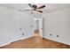 Bright bedroom features wood floors and a ceiling fan, with an open doorway leading to another room at 1518 Rolling Meadow Dr, Valrico, FL 33594